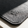 Close-up of water droplets soaking into the microfibre pile of the drying mat