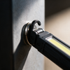 Close-up of the magnetic base and folding hook holding the work light to a steel surface