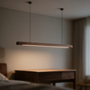 LED pendant light hanging over a bedside table at a low warm setting
