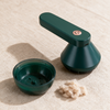 Lint remover with its collection chamber detached and emptied beside it