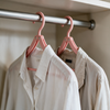 Two travel hangers on a hotel wardrobe rail holding a shirt and a jacket