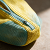Close-up of the zip pull and reinforced corner stitching on the shoe wash bag
