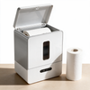 Dispenser opened to show a fresh roll seated inside, with a spare roll alongside