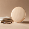The wake-up light switched off beside books and reading glasses, showing its size