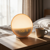 The wake-up light on a bedside table in a bright bedroom in morning daylight
